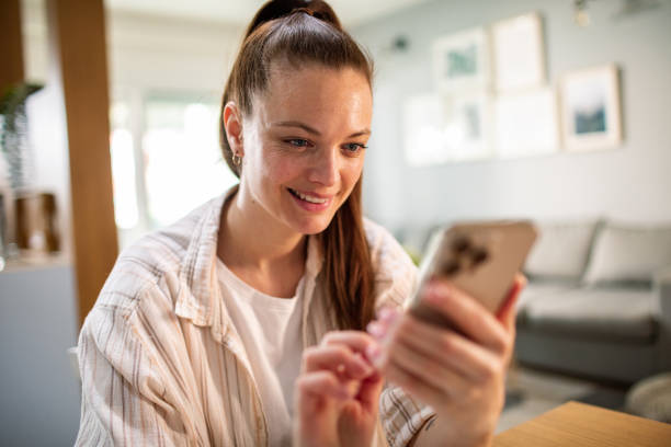 istock Young woman using a smart phone at home 1487587124