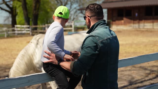 The father teaches his son to care for and love horses