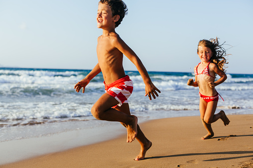 Children having fun running on the beach