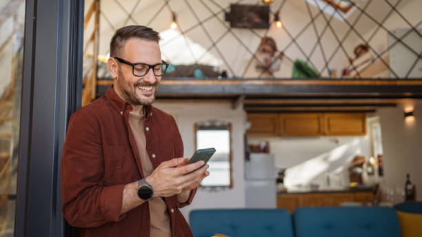 istock Man Stand on Balcony Use Smartphone for sms or texting Happy Smile 1487592825