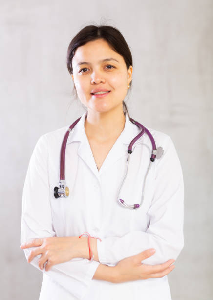 istock Friendly professional female doctor in white coat with phonendoscope 1487593769
