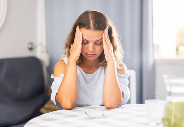 istock Upset young girl sitting at table in her room 1487593805