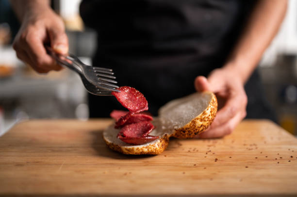 istock A male chef prepares a sausage and cheese sandwich 1487596687