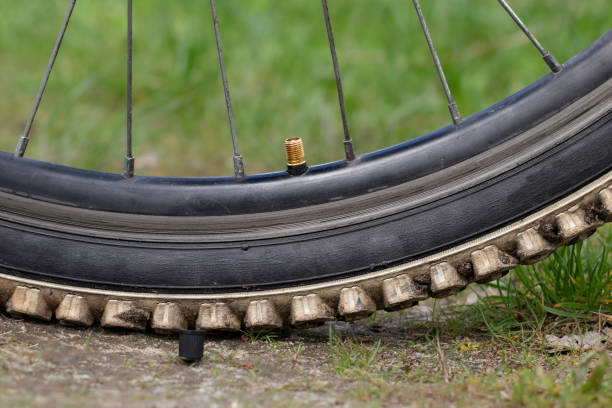 inflação da roda da bicicleta. close-up da roda da bicicleta. abra a tampa da válvula na roda. - bicycle bicycle pump inflating tire - fotografias e filmes do acervo