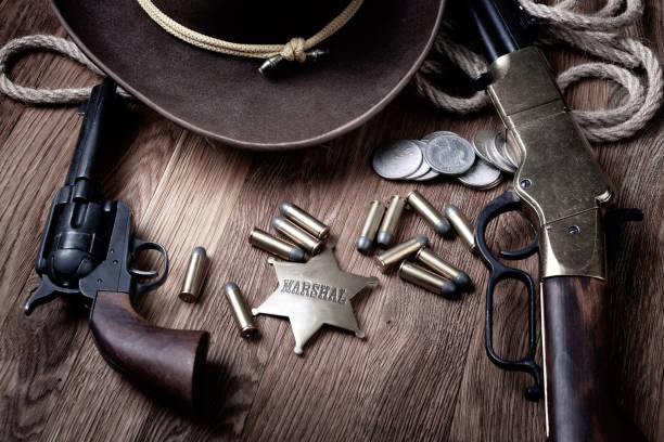 istock Old west rifle, revolver, ammunition and marshal badge with hat 1487610337
