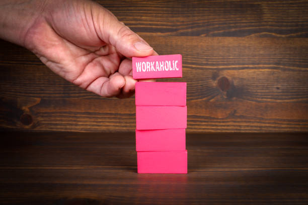 istock Workaholic Concept. Colorful blocks in a pile on a wooden texture background 1487614503
