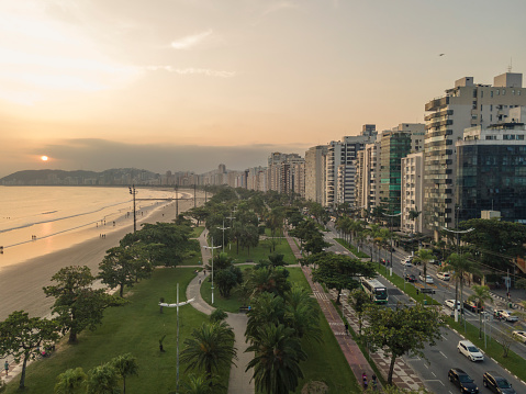 City of Santos, Brazil. Aerial view of the beach at sunset. Buildings, seaside avenue and gardens and beach.