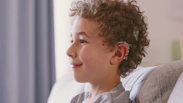 Hearing aid, happy portrait and child disability with sound loss implant for problem in ear. Positive and young kid with device to help with difficulty and struggle with deaf condition.