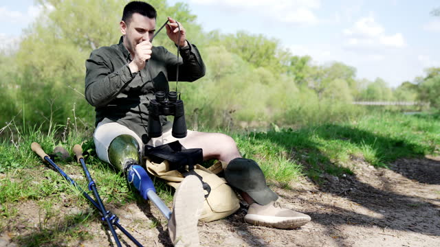 Hiker sitting and using binocular