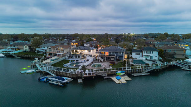 wohlhabende nachbarschaft in einer kleinen stadt am seekanal mit luxusbooten. oceanside, new york, panoramablick aus der luft - long island stock-fotos und bilder