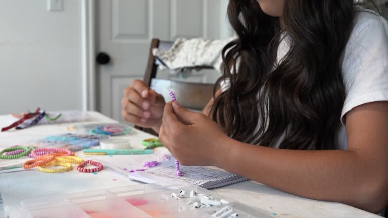 A 12-14 Year Old Girl Inside Her Home is Making Bracelets To Sell to Raise Funds