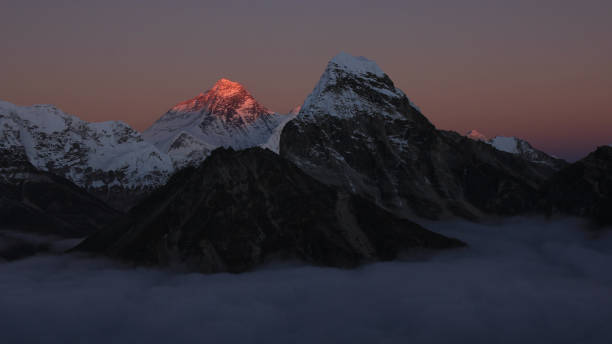 brillante monte everest iluminado rodeado por un mar de niebla. - mt everest fotografías e imágenes de stock