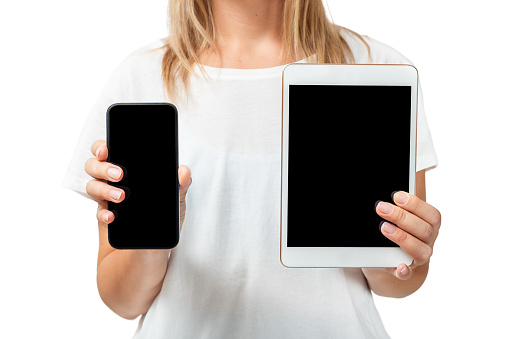 Girl holding phone and tablet with copy space isolated on white background