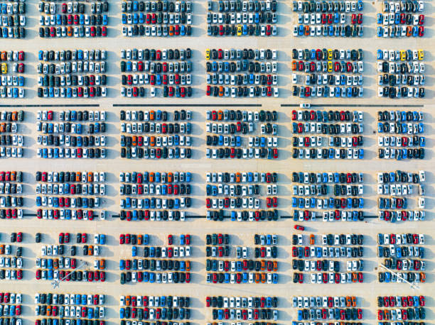 Aerial drone view of Parking lots. New hybrid or electric cars storage area. Many colorful cars parked in a rows