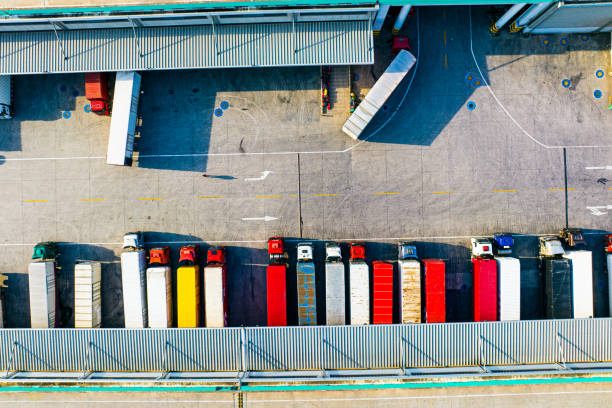 istock Aerial view of trucks loading at logistic center 1487638055