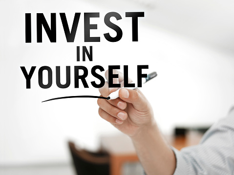 Businessman writing “Invest in yourself
