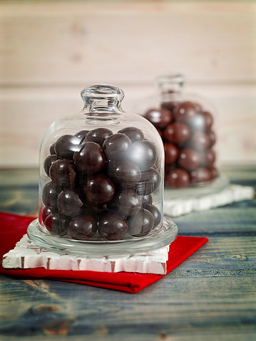 Chocolate drops inside a jar on a table top