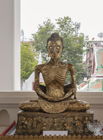 Bangkok, Thailand Apr 18, 2023 - Buddha Statue Brass sitting in Meditation Posture Skinny at Wat Suthat Thepwararam. The Fasting Siddhattha Gotama as a bodhisattva in extremely emaciated forms before he became a Buddha, Fasting, Emaciated, Selective focus.