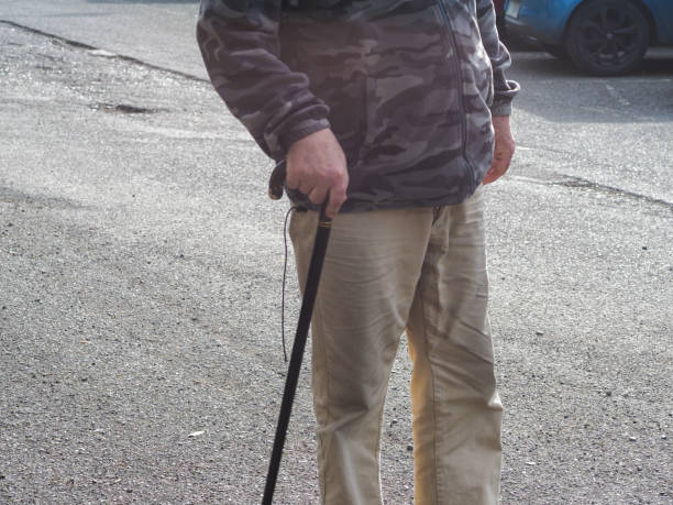 木の杖を持って歩く老人通り - pedestrian senior adult street crossing ストックフォトと画像