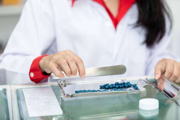 istock asian pharmacist drug counting on counter in pharmacy 1487645174