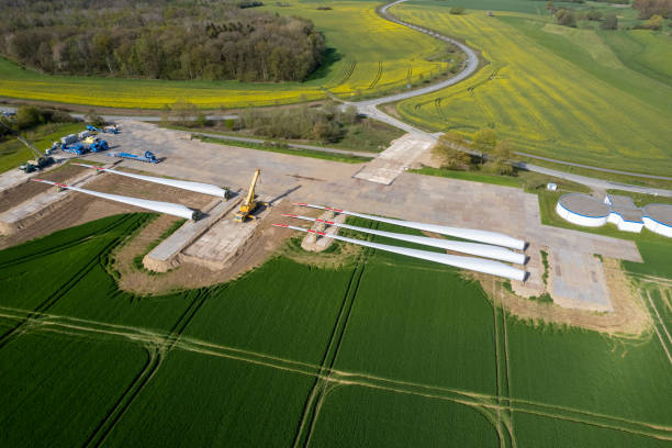 accanto a una strada si trovano le pale del rotore di una turbina eolica - rotor wind turbine tree meadow foto e immagini stock