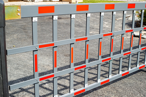 Metal barrier to stop traffic or construction site in a stone road.