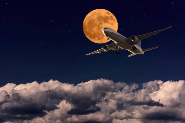 istock Airplane passing the strawberry full moon 1487661474