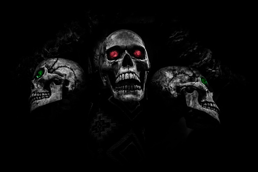 black and white three headed skull and red eye halloween theme concept on dark background.