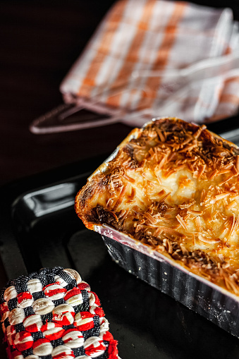 American mac and cheese, macaroni pasta in cheesy sauce. Top side view on the dark background