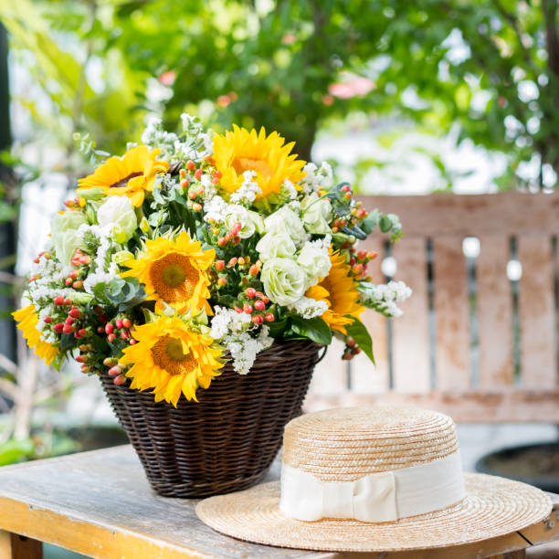 sunflower in the basket  with hat on the table