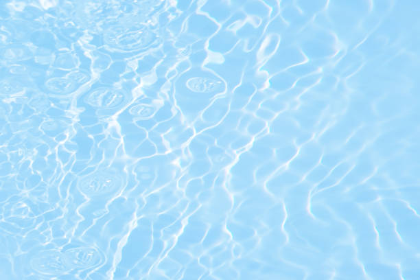 istock Blue water with ripples on the surface. Defocus blurred transparent blue colored clear calm water surface texture with splashes and bubbles. Water waves with shining pattern texture background. 1487667581