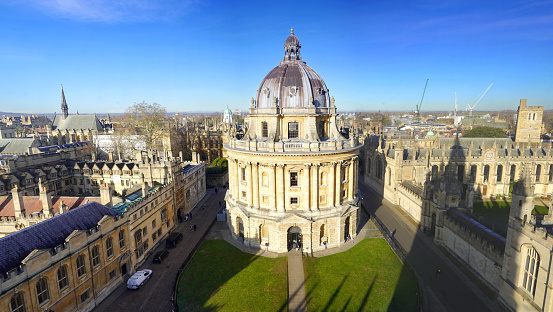 Aerial establishing shot of Oxford, England, flying over the city centre buildings and the colleges and libraries of the famous university.