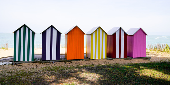 wooden brightly coloured beach huts on West atlantic beach french in summertime
