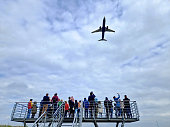 Group of people watching an airplane taking off.