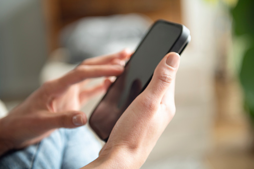 Closeup view of woman holding modern smartphone in hands