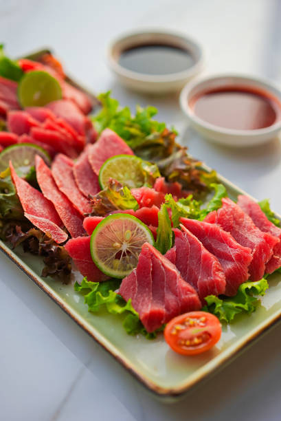 istock Tuna sashimi with vegetables and sauce 1487678054