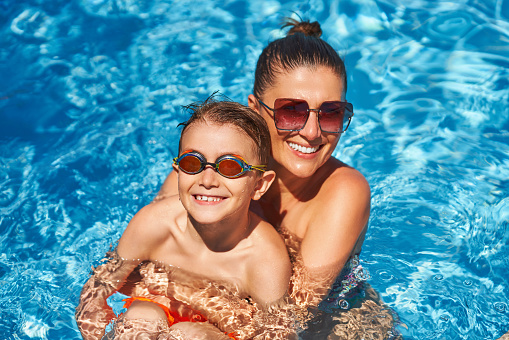 Image of mother with son in the pool. High quality photo