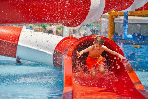Picture of young boy playing in outdoor aqua park. High quality photo