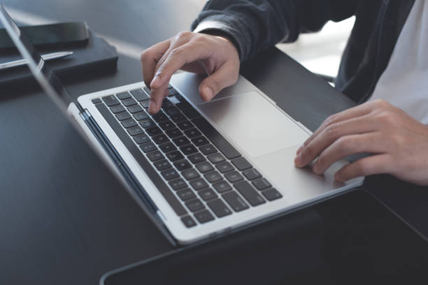 istock Close up of man hands working, typing on laptop computer, browsing the internet, networking at home office, online working, freelancer at work, telecommuting concept 1487682350