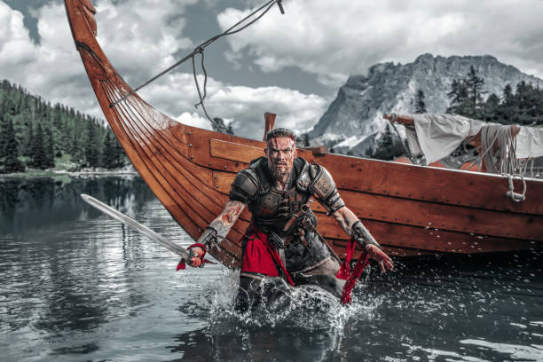 Viking Warrior sailing on a fjord on an authentic viking long boat stock photo