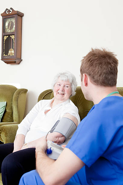 Nurse checking senior ladys blood pressure