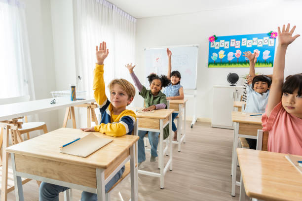 Group of student learn with teacher in classroom at elementary school. Attractive beautiful female instructor master explain and educate young children with happiness and fun activity at kindergarten.