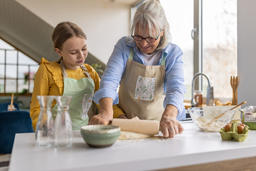 Grandmother and granddaughter making bread in the kitchen together
