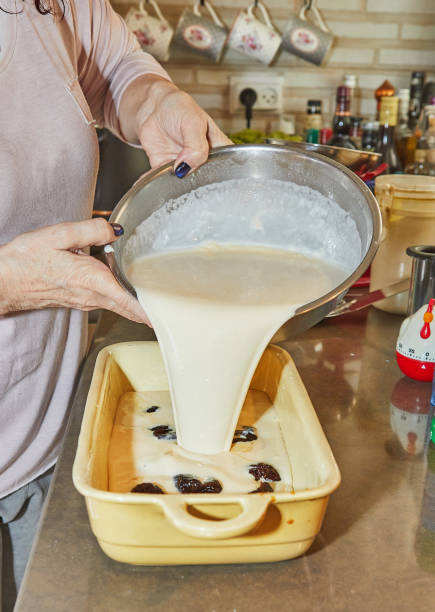 istock Chef puts the dough into ceramic mold with plums to make plum cake 1487688480