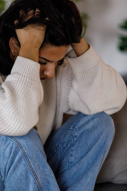 istock Distraught young woman sitting with head in hands, struggling with negative emotions 1487688751