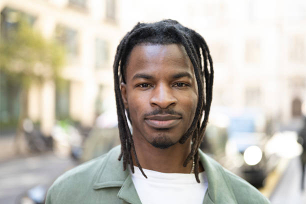 Headshot portrait of mid adult black man in city street stock photo