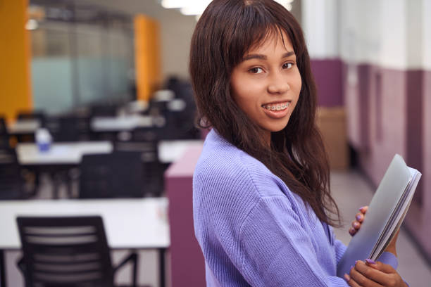 istock Happy female worker standing in open space office 1487692335