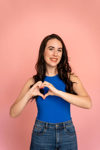 istock Smiling woman making love gesture with her hands. 1487693151