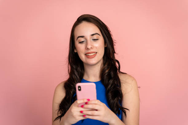istock Smiling woman using a smartphone in a studio shot. 1487694057