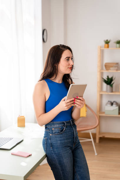 istock Woman working remotely looking at emails on digital tablet. 1487695067